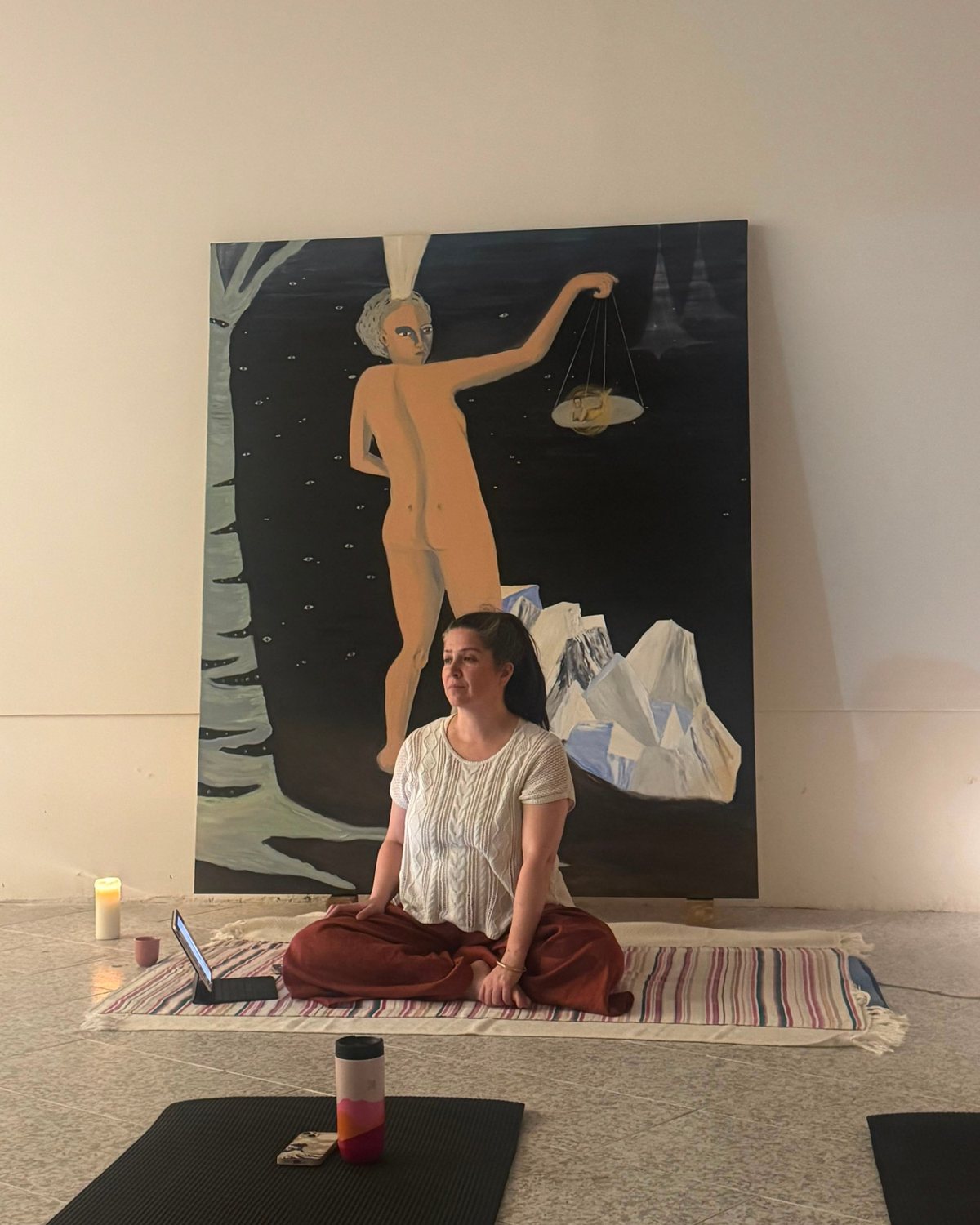 Diana González sentada en la práctica, frente a una obra de Luz Lizarazo